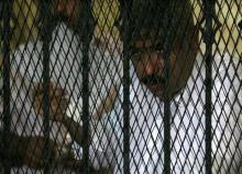 Hesham Talaat Moustafa, former chairman of the Talaat Moustafa Group, stands inside a cage at a court in Cairo, Egypt, June 25, 2009. PHOTO BY REUTERS/Asmaa Waguih