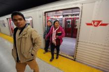 Honduran migrants Raul Contreras (L), his mother Daysi Alas (R) and step-father Ananin Cruz, who are seeking refugee status in Canada, exit a subway car while travelling to attend a church service held in Spanish in Toronto, Ontario, Canada, April 8, 2017. PHOTO BY REUTERS/Chris Helgren