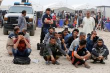 Displaced Iraqi men who fled their homes during a battle between Iraqi forces and Islamic State militants, wait for a security check at Hammam al-Alil camp checkpoint south of Mosul, Iraq, April 18, 2017. PHOTO BY REUTERS/Muhammad Hamed