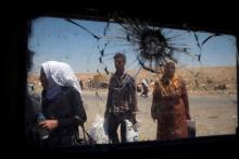Displaced Iraqi civilians are seen through a shattered glass window of an Iraqi forces armoured fighting vehicle in West Mosul, Iraq, June 27, 2017. PHOTO BY REUTERS/Erik De Castro