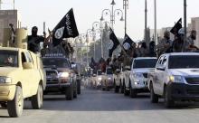 Militant Islamist fighters parade on military vehicles along the streets of northern Raqqa province, June 30, 2014. PHOTO BY REUTERS/Stringer