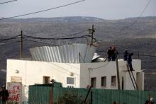 Jewish youths stand atop a roof in the Jewish settler outpost of Amona in the West Bank, December 18, 2016. PHOTO BY REUTERS/Baz Ratner
