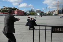 A plain clothes police officer points his gun at an assailant who attempted to shoot prominent Turkish journalist Can Dundar, outside a courthouse in Istanbul, Turkey, May 6, 2016. PHOTO BY REUTERS/Can Erok