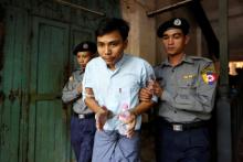 Detained Reuters journalist Kyaw Soe Oo is escorted by police before a court hearing in Yangon, Myanmar, April 11, 2018. PHOTO BY REUTERS/Ann Wang