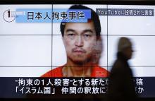 A man walks past screens displaying a television news program showing an image of Kenji Goto, one of two Japanese citizens taken captive by Islamic State militants, on a street in Tokyo, January 25, 2015. PHOTO BY REUTERS/Yuya Shino
