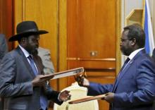 South Sudan's rebel leader Riek Machar (R) and South Sudan's President Salva Kiir exchange signed peace agreement documents in Addis Ababa, May 9, 2014. PHOTO BY REUTERS/Goran Tomasevic