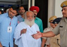 Police escort spiritual leader Asaram Bapu (C) outside an airport after his arrest in Jodhpur, in the desert state of Rajasthan, India, September 1, 2013. PHOTO BY REUTERS/Stringer