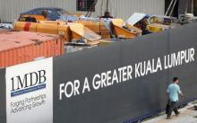 A man walks past a 1 Malaysia Development Berhad (1MDB) billboard at the funds flagship Tun Razak Exchange development in Kuala Lumpur, March 1, 2015. PHOTO BY REUTERS/Olivia Harris