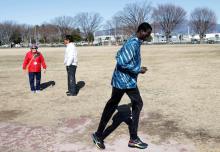 Abraham Majok from South Sudan runs past Japanese volunteers during his training in preparation for the Tokyo 2020 Olympics in Maebashi, Gunma Prefecture, Japan, February 4, 2020. PHOTO BY REUTERS/Kim Kyung-Hoon