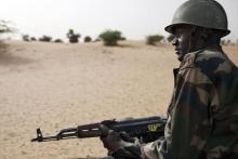 A Malian soldier, holding an AK-47 rifle, rides in a pick-up truck during a military escort outside Timbuktu, Mali, July 27, 2013. PHOTO BY REUTERS/Joe Penney