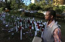 A man walks near wooden crosses as Kenyans continue to pay their respects to the students killed by gunmen at Garissa University College, at the "Freedom Corner" in Kenya's capital Nairobi, April 9, 2015. PHOTO BY REUTERS/Noor Khamis