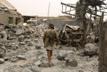 An armed man walks on the rubble of the collapsed house of General Ali al-Dhafif, a Yemeni army brigade commander, after it was hit by Saudi-led air strikes near Sanaa, Yemen, June 9, 2015. PHOTO BY REUTERS/Khaled Abdullah