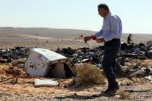 An Egyptian man puts flowers near debris at the crash site of a Russian airliner in al-Hasanah area at El Arish city, north Egypt, November 1, 2015. PHOTO BY REUTERS/Mohamed Abd El Ghany
