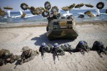 South Korean (blue headbands) and U.S. Marines take positions as amphibious assault vehicles of the South Korean Marine Corps fire smoke bombs during a U.S.-South Korea joint landing operation drill in Pohang, South Korea, March 12, 2016. PHOTO BY REUTERS/Kim Hong-Ji