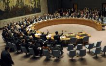 Members of the United Nations Security Council raise their hands as they vote unanimously to approve a resolution eradicating Syria's chemical arsenal