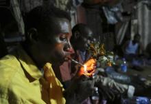 Somali men smoke and chew khat inside a makeshift building at night in Mogadishu, August 6, 2014. PHOTO BY REUTERS/Feisal Omar