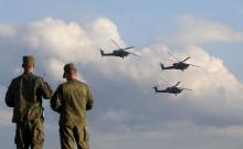Russian servicemen watch Mi-28 military helicopters of the Berkuti (Golden Eagles) aerobatic team fly during the opening of the Army-2015 international military forum in Kubinka, outside Moscow, Russia, June 16, 2015. PHOTO BY REUTERS/Maxim Shemetov