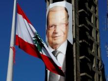 A Lebanese flag flutters near a picture of Christian politician and FPM founder Michel Aoun on a building prior to presidential elections in Beirut, Lebanon, October 30, 2016. PHOTO BY REUTERS/Mohamed Azakir