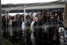 Migrants with their belongings stand in line as French police evacuate hundreds of migrants living in makeshift camps in Paris, France, May 30, 2018. PHOTO BY REUTERS/Benoit Tessier