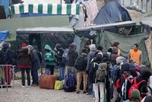 Migrants with their belongings queue at the start of their evacuation and transfer to reception centers in France, and the dismantlement of the camp called the "Jungle" in Calais, France, October 24, 2016. PHOTO BY REUTERS/Pascal Rossignol