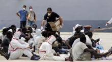 Migrants receive meals after disembarking from Italian Navy vessel Fenice in the Sicilian harbour of Augusta, Italy, May 31, 2015. PHOTO BY REUTERS/Antonio Parrinello