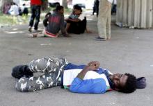 A migrant sleeps on the street next to the Tiburtina station in Rome, June 11, 2015. PHOTO BY REUTERS/Alessandro Bianchi