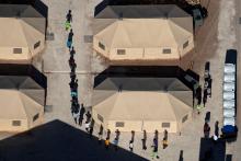 Immigrant children are led by staff in single file between tents at a detention facility next to the Mexican border in Tornillo, Texas, U.S., June 18, 2018. PHOTO BY REUTERS/Mike Blake