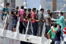 Migrants disembark from Italian Coast Guard vessel "Diciotti" in the Sicilian harbour of Palermo, Italy, August 20, 2015. PHOTO BY REUTERS/Guglielmo Mangiapane