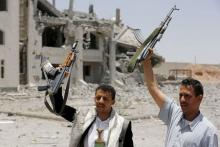 Houthi militants gesture in the yard of the residence of the military commander of the Houthi militant group, Abdullah Yahya al Hakim, after it was hit by an airstrike, in Sanaa, April 28, 2015. PHOTO BY REUTERS/Khaled Abdullah