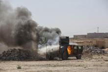 A military vehicle, belonging to Shi'ite fighters known as Hashid Shaabi, burns after being hit by Islamic State militants, during clashes in northern Tikrit, March 11, 2015. PHOTO BY REUTERS/Stringer