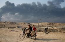 Armed members of Shi'ite militia Hashid Shaabi ride a motorbike near Qayyara, south of Mosul, Iraq, October 27, 2016. PHOTO BY REUTERS/Goran Tomasevic