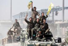 Kurdish-led militiamen ride atop military vehicles as they celebrate victory over Islamic State in Raqqa, Syria, October 17, 2017. PHOTO BY REUTERS/Erik De Castro