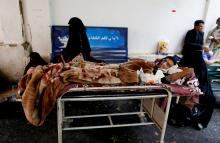 Mohammed al-Hosami sits next to his mother who has cancer on a bed at a cancer treatment center in Hodeidah, Yemen, July 23, 2018. "There is no work or salary so we can't afford transportation costs, and the village helped me with the payments for treatment," al-Hosami said. PHOTO BY REUTERS/Abduljabbar Zeyad