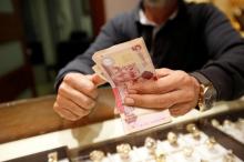 A man counts Libyan dinars at a currency exchange office in Tripoli, April 24, 2016. PHOTO BY REUTERS/Ismail Zitouny