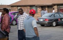 People stand outside an Islamic mosque located within an apartment complex, which federal authorities allege was to be targeted in a bomb plot by three Kansas men, is seen in Garden City, Kansas, U.S., October 14, 2016. PHOTO BY REUTERS/Adam Shrimplin