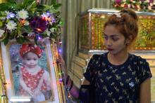 Jiranuch Trirat, mother of 11-month-old daughter who was killed by her father who broadcast the murder on Facebook, stands next to a picture of her daughter at a temple in Phuket, Thailand, April 25, 2017. PHOTO BY REUTERS/Sooppharoek Teepapan