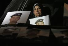Mother of Islamic State captive Jordanian pilot Muath al-Kasaesbeh holds his picture while sitting in a car, as she takes part in a demonstration demanding that the Jordanian government negotiate with Islamic state and for the release of her son, in front of the prime minister's building in Amman, January 27, 2015. PHOTO BY REUTERS/Muhammad Hamed