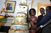Zimbabwean President Robert Mugabe (R) is helped by his wife Grace (L) and son Chatunga (C) to cut a cake to celebrate his 92nd birthday at State House in Harare, February 22, 2016. Mugabe turned 92 on Sunday. PHOTO BY REUTERS/Philimon Bulawayo