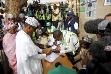 An electoral officer attends to All Progressives Congress presidential candidate and Nigeria's former military ruler Muhammadu Buhari as he verifies his voter's card at a polling unit at the begining of general elections in Daura, March 28, 2015. PHOTO BY REUTERS/Akintunde Akinleye