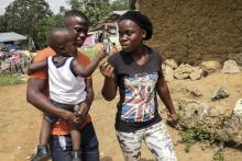 Musa Pabai holds his son Oliver and walks with his girlfriend Hannah Wright (R), upon meeting them for the first time after surviving Ebola, at their home in Walakor, February 19, 2015. PHOTO BY REUTERS/Ricci Shryock