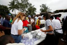 A non-governmental organisation (NGO) is seen distributing meals to victims of the mudslide at the internally displaced persons camp in Regent, Sierra Leone, August 19, 2017. PHOTO BY REUTERS/Afolabi Sotunde