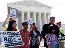Naomi Lien,10, is comforted by Pastor Seth Kaper-Dale as she they react with other immigration rights proponents outside the U.S. Supreme Court after the Court upheld U.S. President Donald Trump's travel ban targeting several Muslim-majority countries, in Washington, U.S., June 26, 2018. PHOTO BY REUTERS/Leah Millis