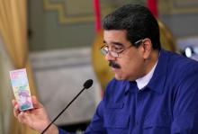 Venezuela's President Nicolas Maduro holds a bank note of the new Venezuela's currency Bolivar Soberano (Sovereign Bolivar) as he speaks during a meeting with ministers at Miraflores Palace in Caracas, Venezuela, July 25, 2018. PHOTO BY REUTERS/Miraflores Palace