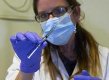 A nurse holds a syringe containing an experimental Ebola virus vaccine during a media visit at the Lausanne University Hospital (CHUV) in Lausanne, November 4, 2014. PHOTO BY REUTERS/Denis Balibouse