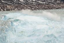 Ocean water is pushed up by the bottom of a pinnacle iceberg as it falls back during a large calving event at the Helheim glacier near Tasiilaq, Greenland, June 22, 2018. PHOTO BY REUTERS/Lucas Jackson