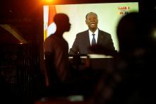 People watch the speech of Ivory Coast President, Alassane Ouattara, on a screen in Palmeraie, Abidjan, Ivory Coast, August 6, 2018. PHOTO BY REUTERS/Thierry Gouegnon