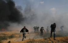 Palestinian demonstrators run for cover during clashes with Israeli troops at a protest demanding the right to return to their homeland, at the Israel-Gaza border in the southern Gaza Strip, April 27, 2018. PHOTO BY REUTERS/Ibraheem Abu Mustafa