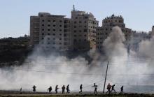 Palestinian protesters run away from tear gas fired by Israeli troops during clashes near the Jewish settlement of Bet El, near the West Bank city of Ramallah, November 13, 2015. PHOTO BY REUTERS/Mohamad Torokman