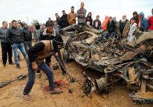 Palestinians inspect the remains of a vehicle that was destroyed in an Israeli air strike, in Khan Younis in the southern Gaza Strip, November 12, 2018. PHOTO BY REUTERS/Suhaib Sale