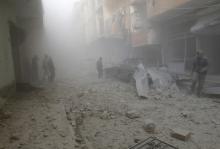 People walk on rubble as they inspect a site hit by what activists said were airstrikes by forces loyal to Syria's President Bashar al-Assad in Raqqa, eastern Syria, which is controlled by the Islamic State, November 27, 2014. PHOTO BY REUTERS/Nour Fourat